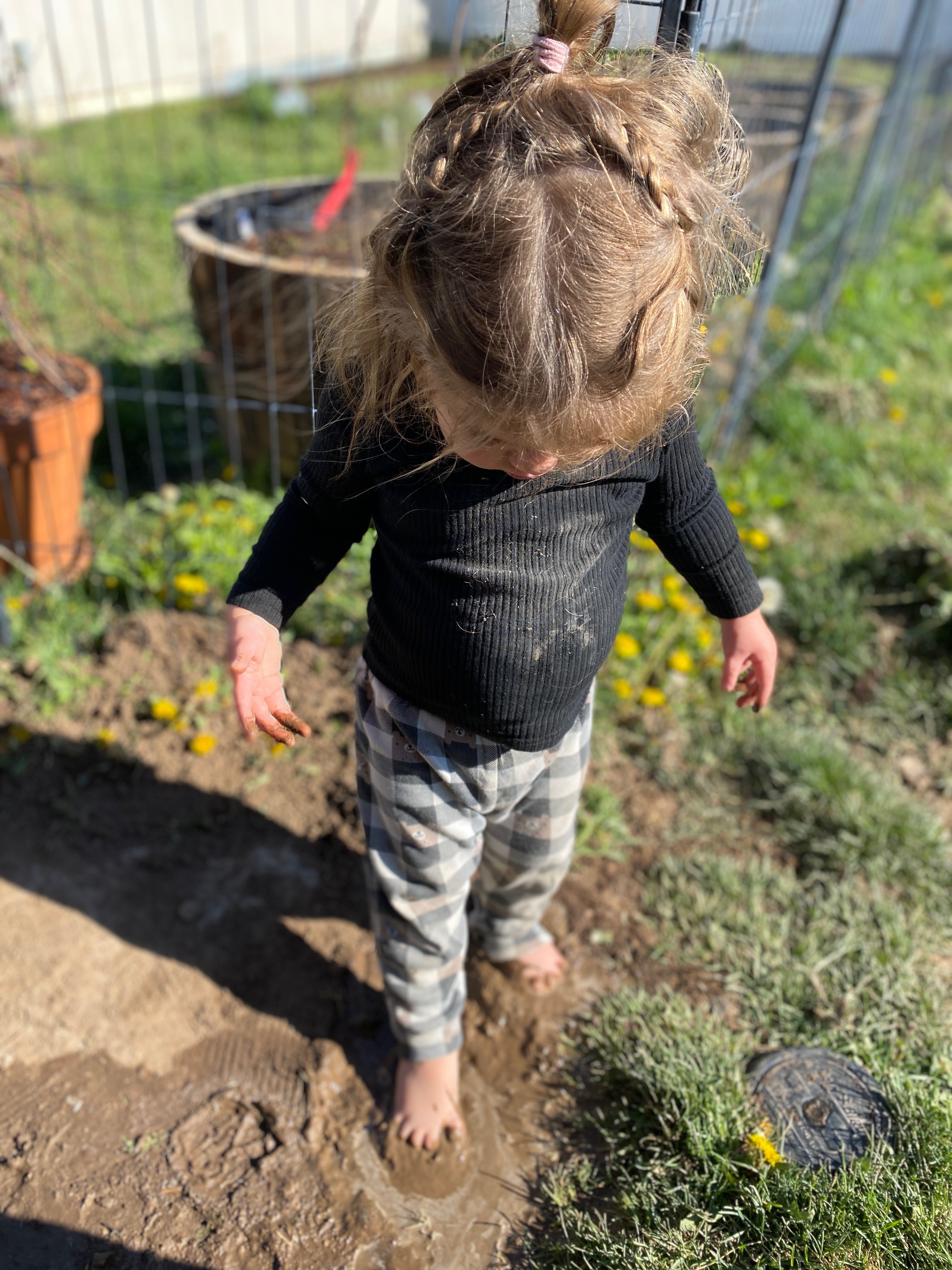 A little girl with braids exploring the garden — childhood wonder and slow living