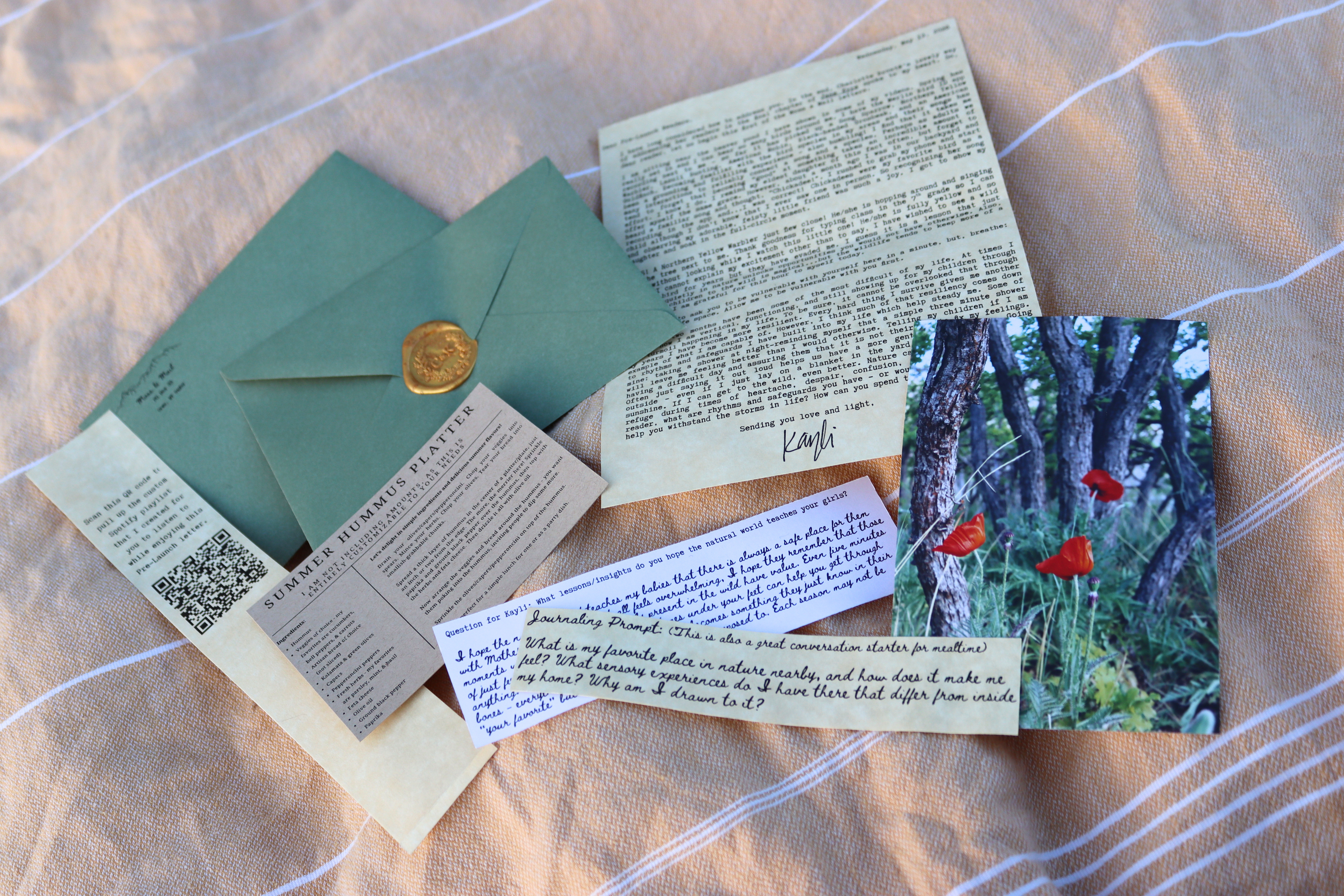 Moss and Mail envelope contents spread out — letter, wax seal, recipe card, photo postcard